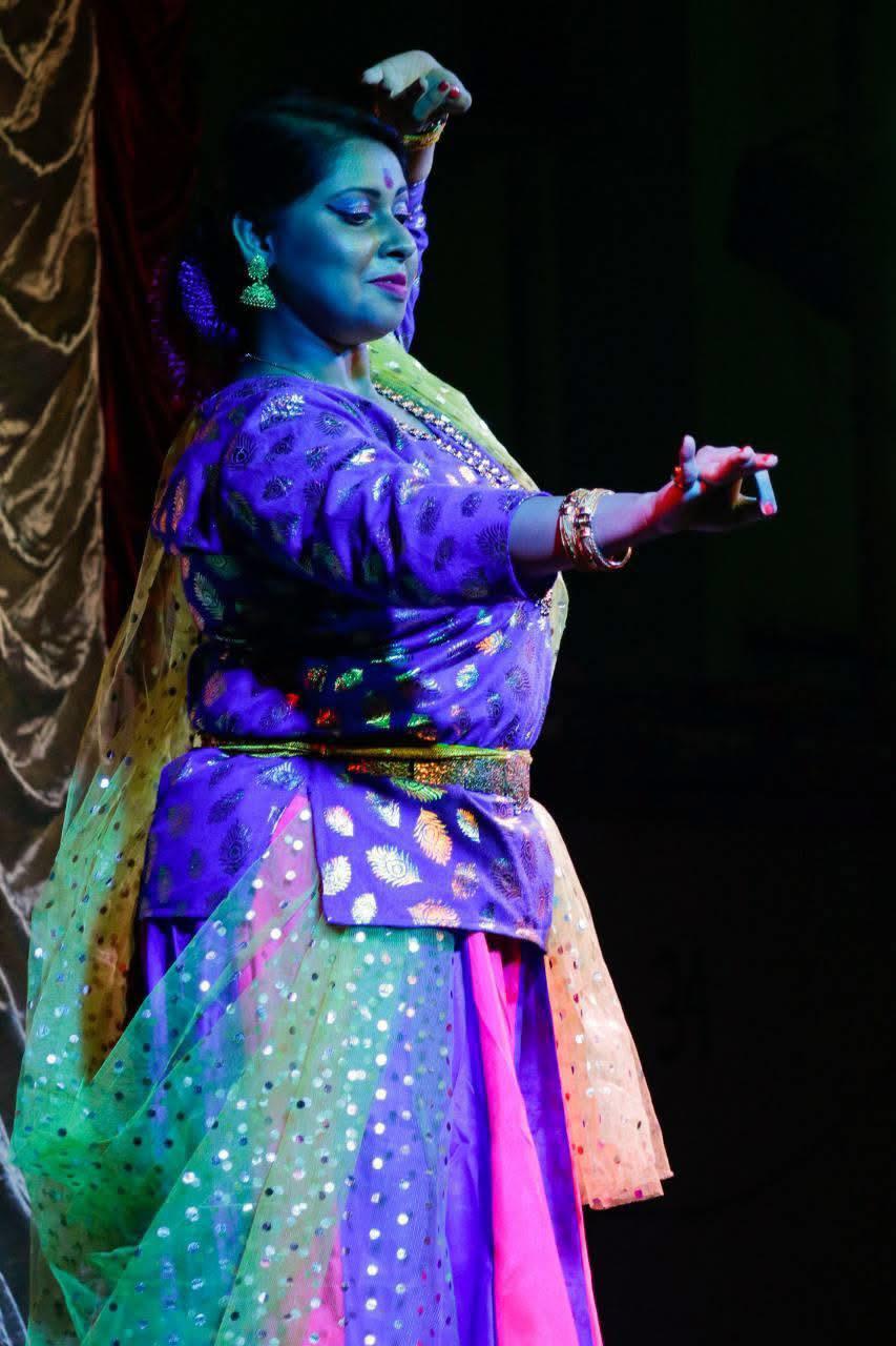 Aishwarya Bag performing a classical dance under colourful stage lighting