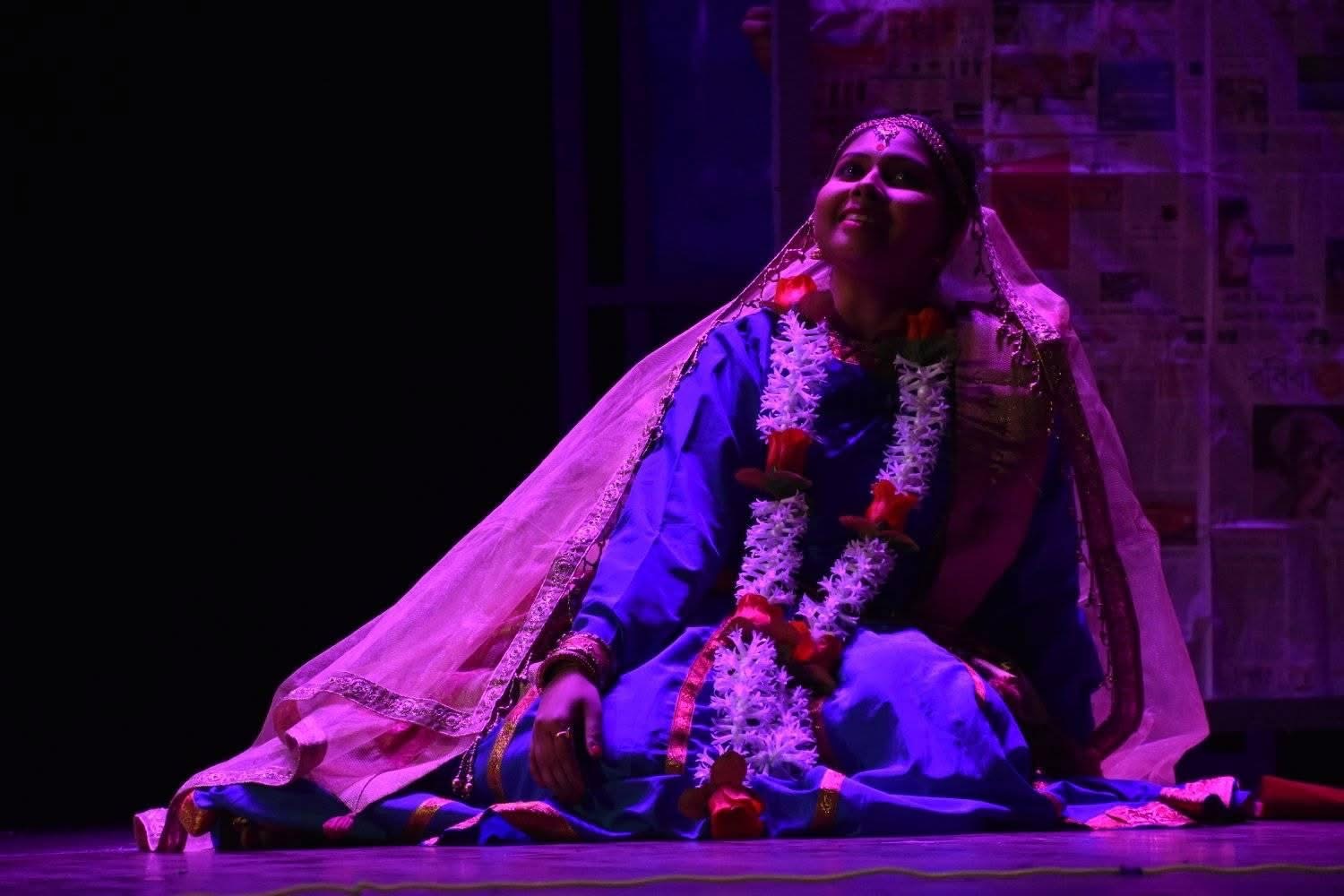 Aishwarya Bag in a classical dance pose under red stage lighting