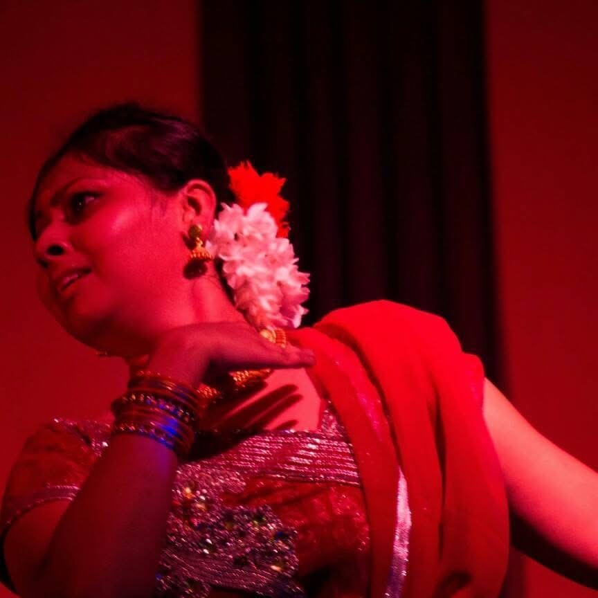 Classical dance pose in teal and red costume