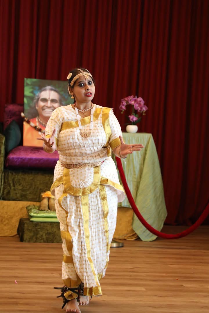 Classical dance pose in a white and gold saree
