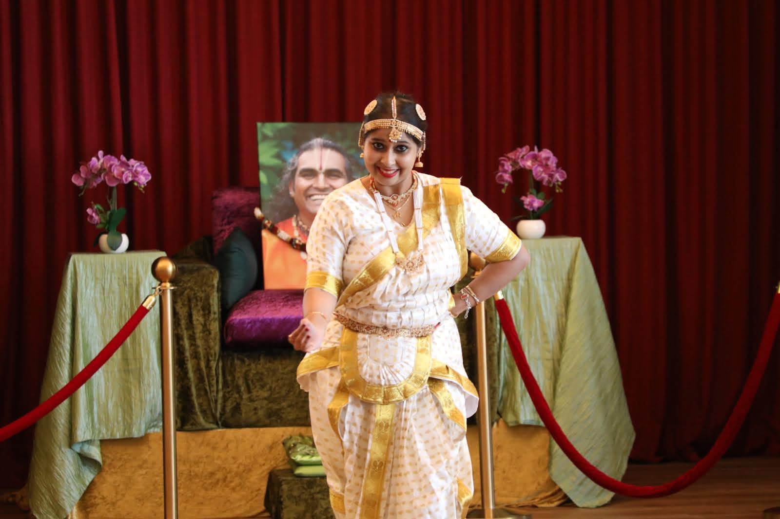 Classical dance pose on stage in white and gold costume